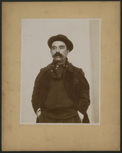 [Portrait photographique de Denys Puech debout mains dans les poches]
